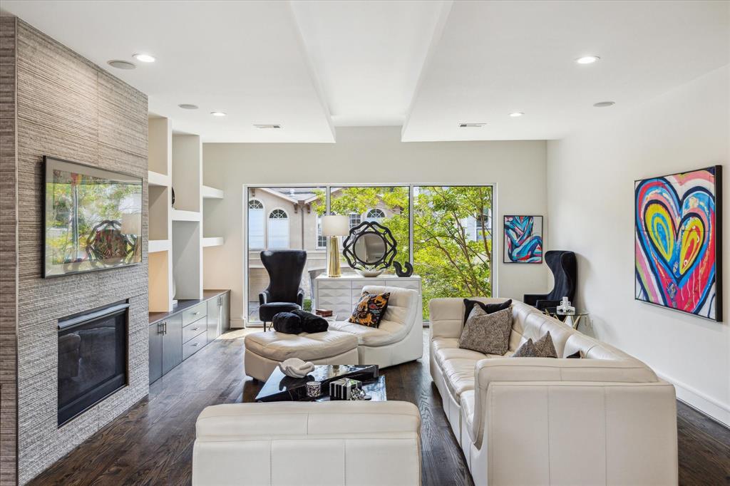 28x19 LIVING ROOM here showcases tiled fireplace and built-ins backset to a wall of aluminum framed picture windows (overlooking W. Pierce Street) and oak floors throughout.