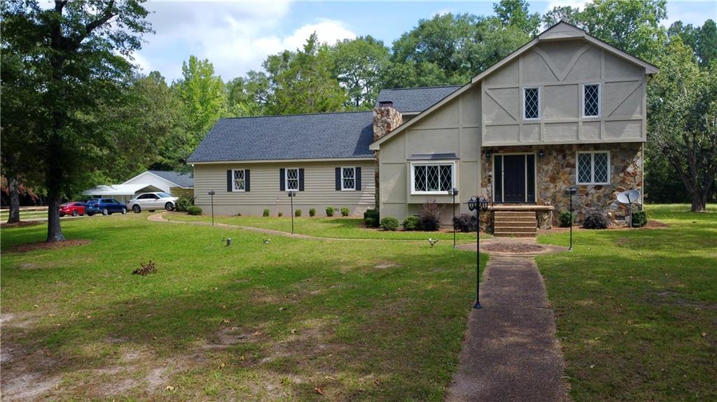 a front view of a house with a yard and trees