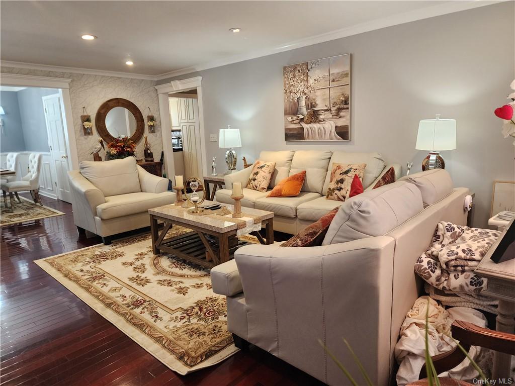 Living room with hardwood flooring and ornamental molding