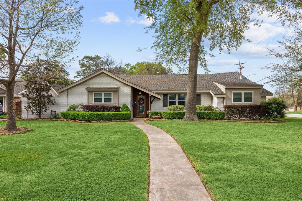 a front view of a house with a yard and trees