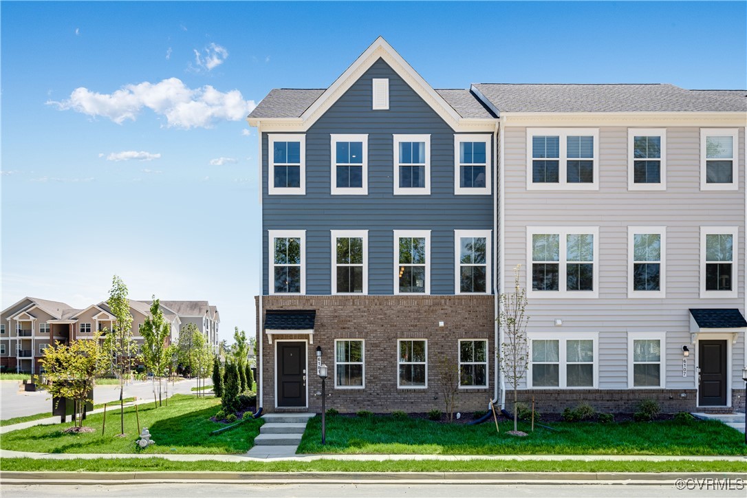 a front view of a residential apartment building with a yard