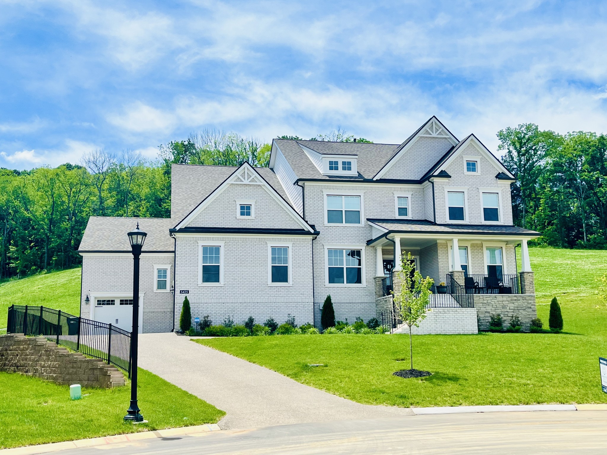 a front view of a house with a yard and trees