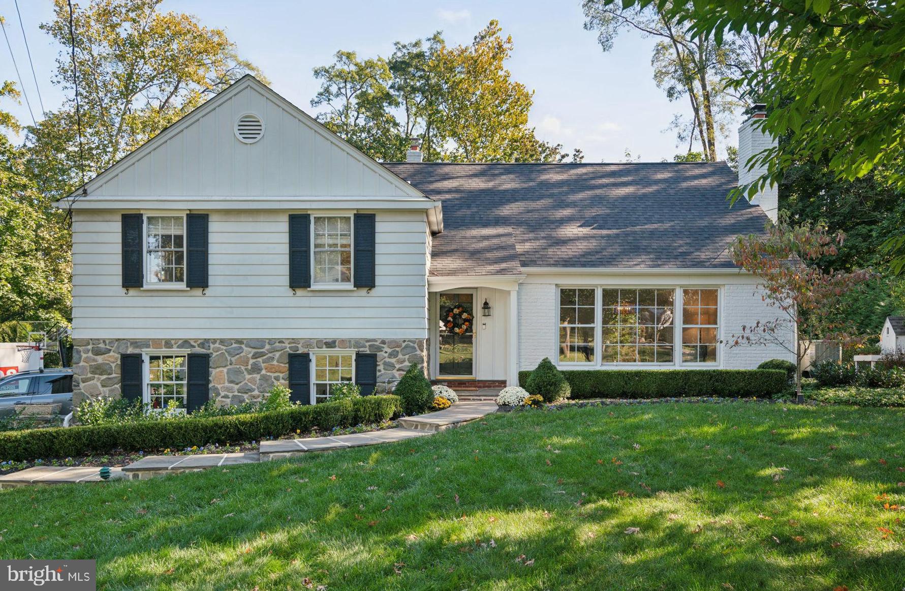 a front view of a house with a yard and green space