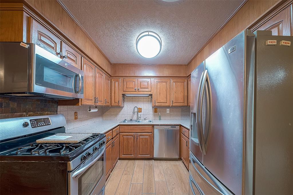 a kitchen with stainless steel appliances granite countertop a stove a sink and a refrigerator