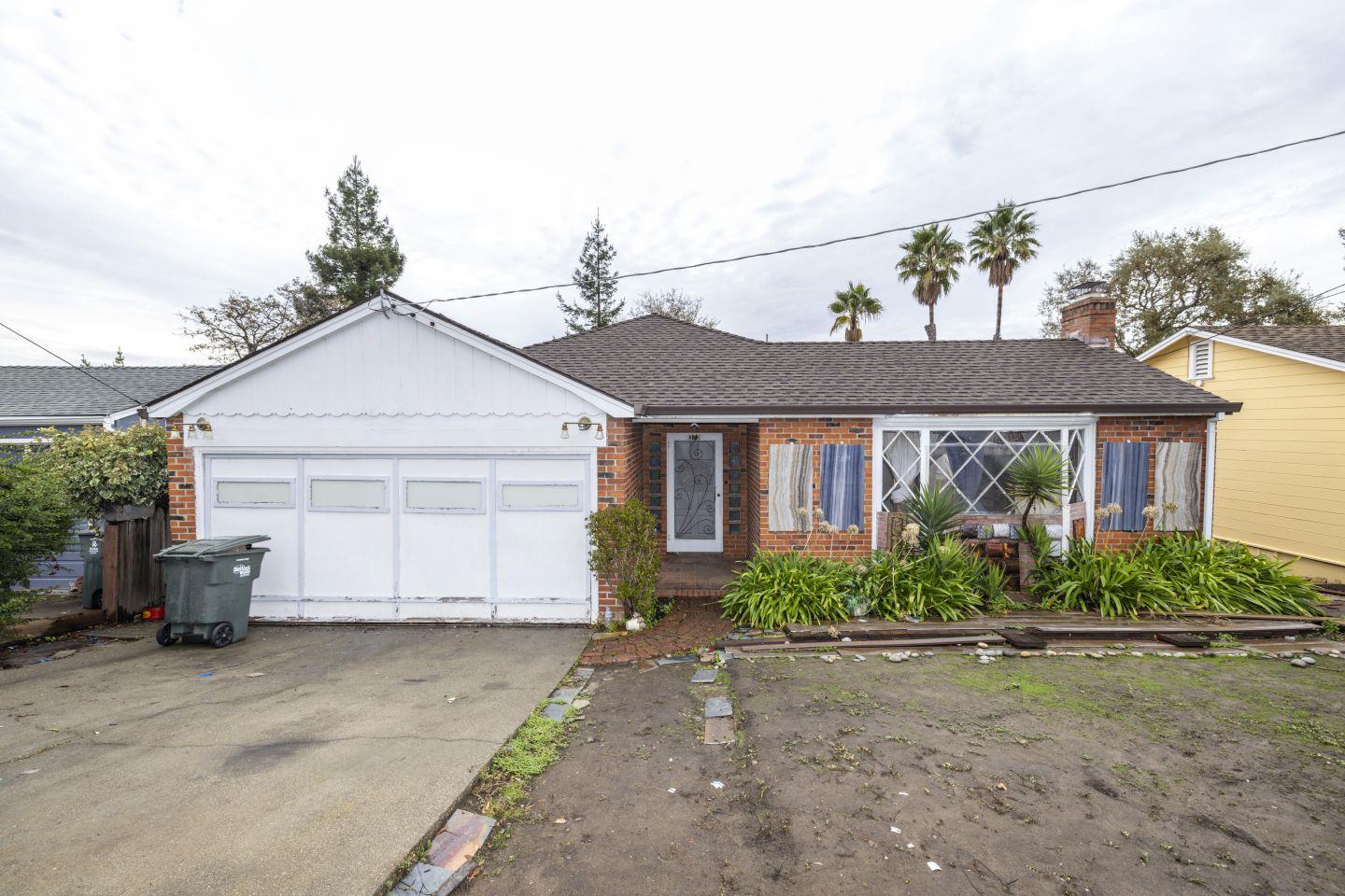 a front view of a house with a yard and potted plants