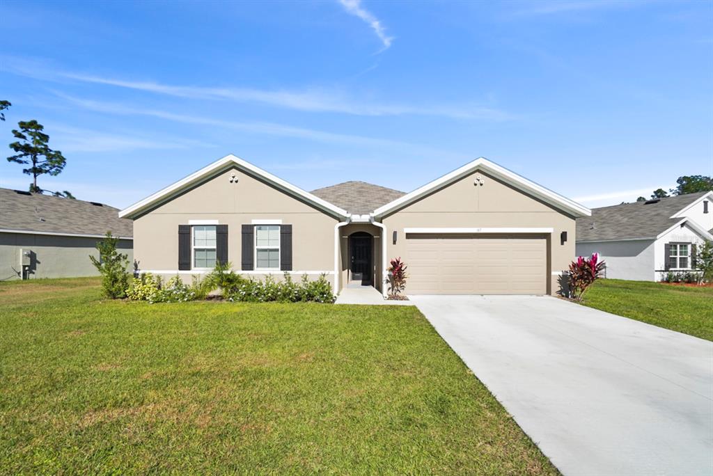 a front view of a house with a yard and garage