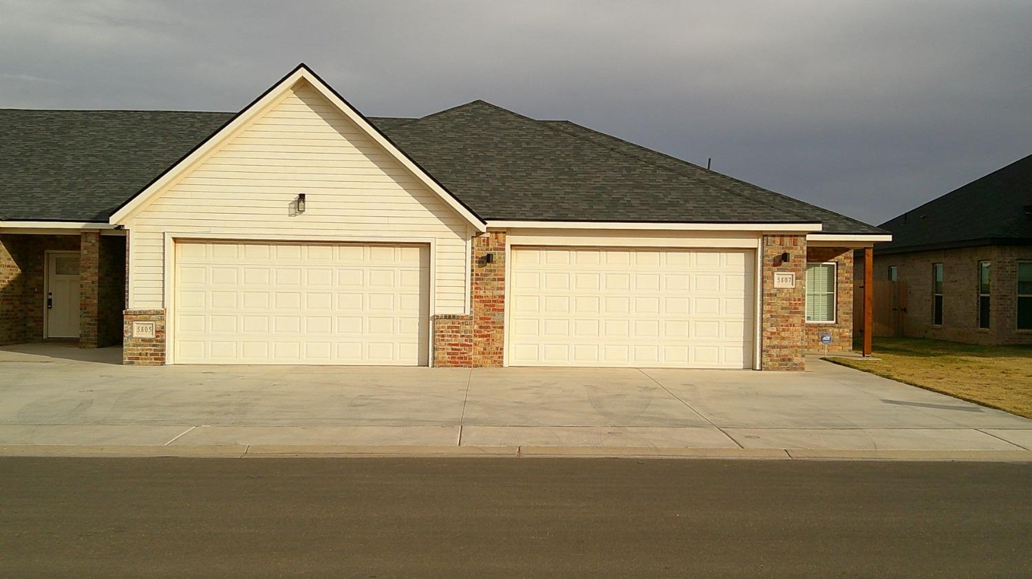 a view of an house with backyard and parking