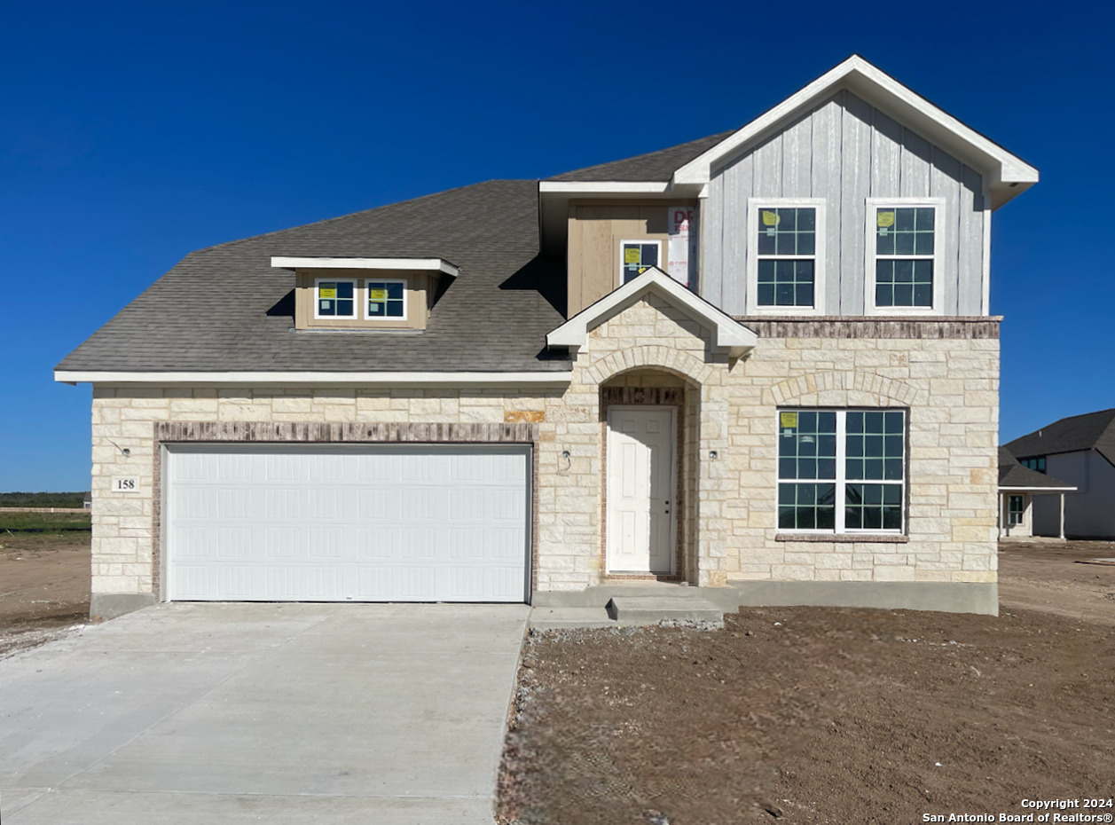 a front view of a house with a garage and yard