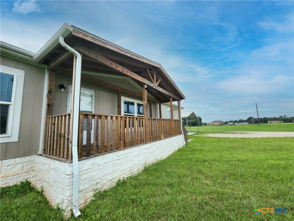 a view of backyard with barbeque grill and wooden fence