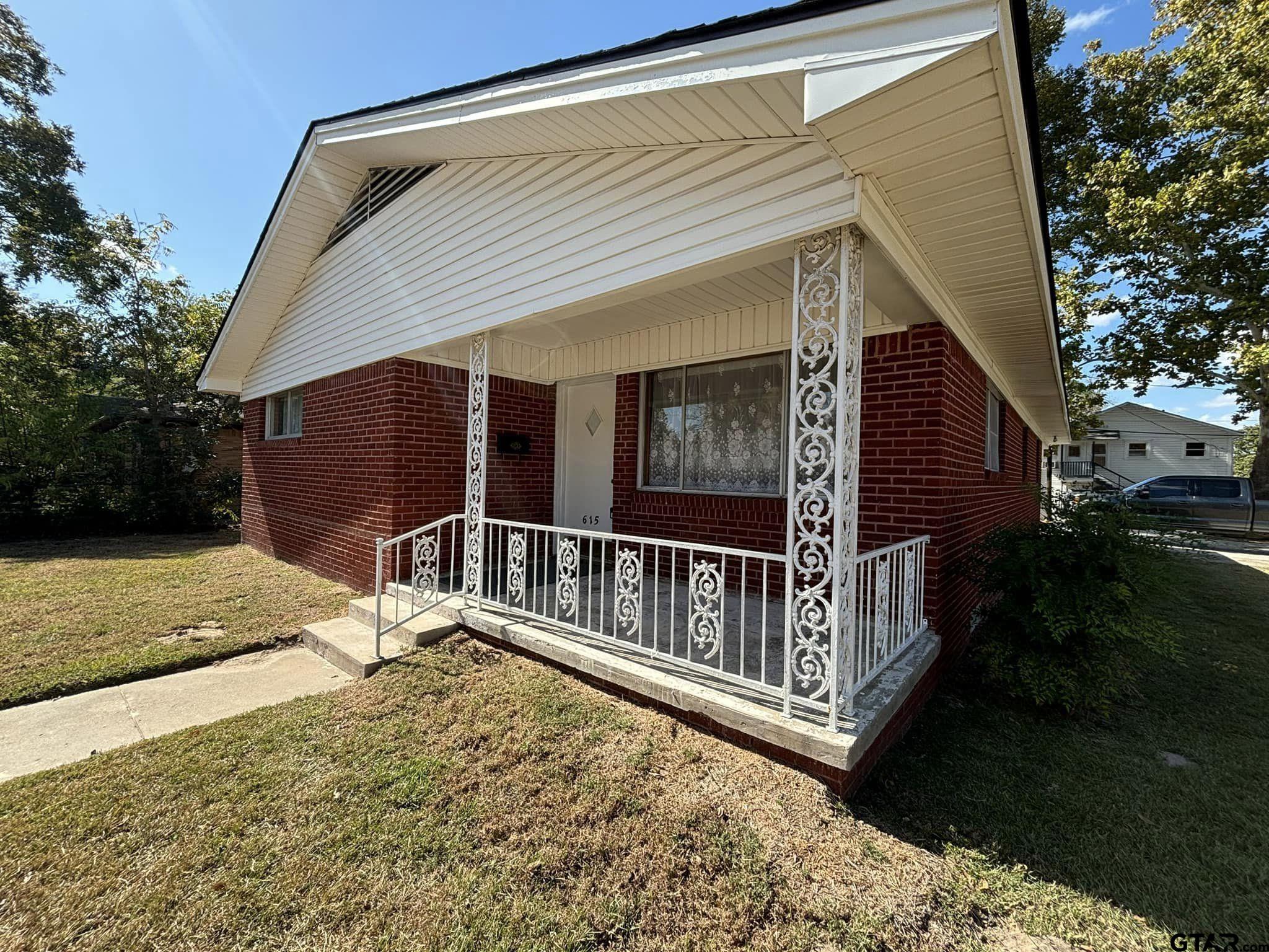 a view of house with backyard and porch