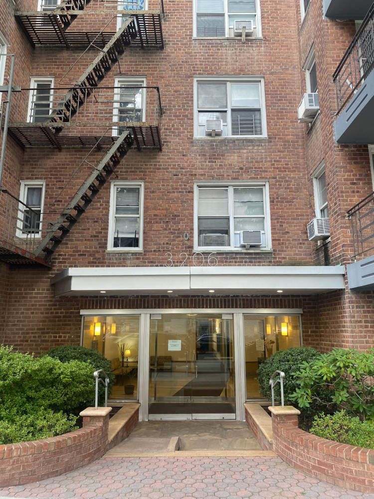 a front view of a building with a garden and plants