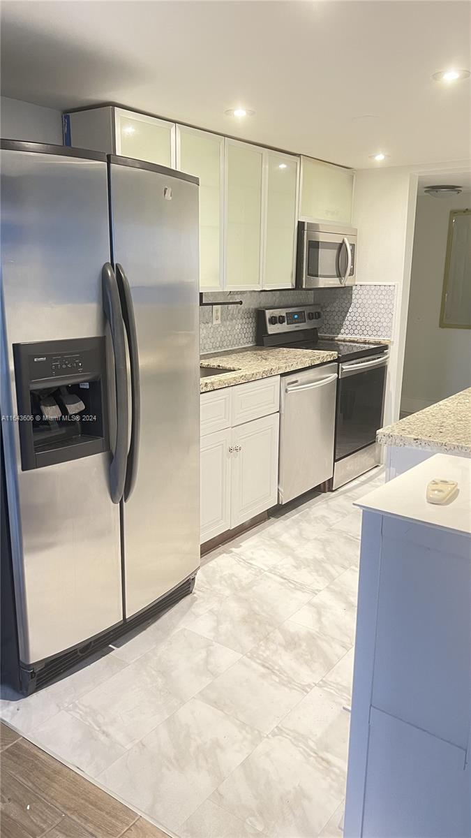 a kitchen with stainless steel appliances a refrigerator sink and microwave