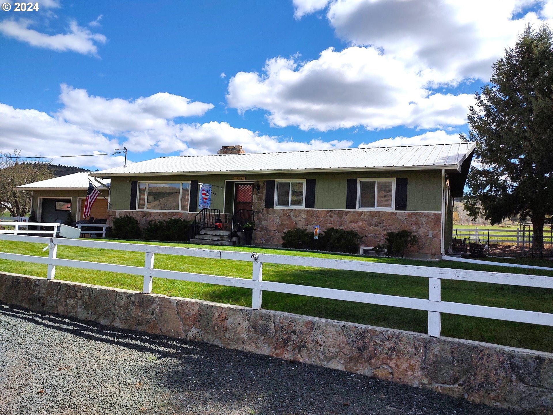 a view of a house that has a big wooden fence and a big yard