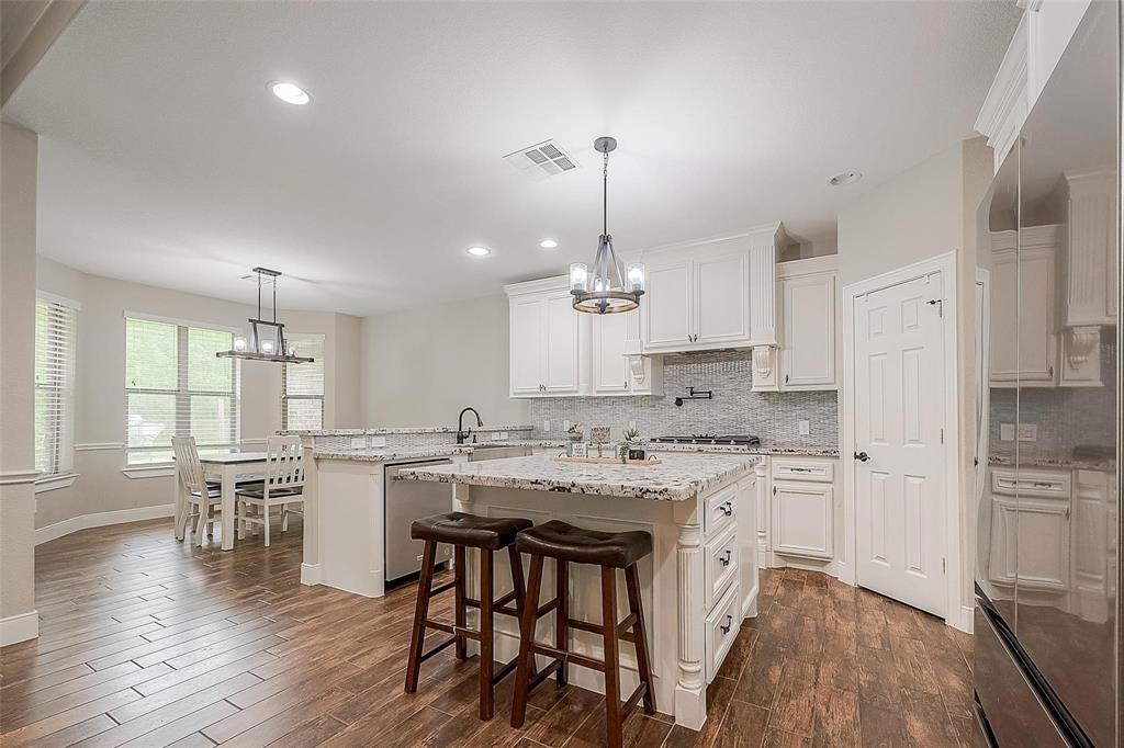 This seamless open-concept kitchen has an inviting breakfast nook and a view of the large, open back yard