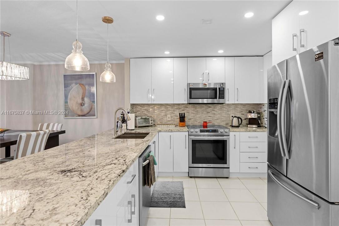 a kitchen with kitchen island a sink stainless steel appliances and cabinets