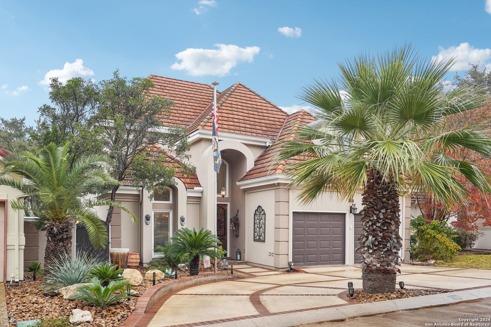 a front view of a house with a tree