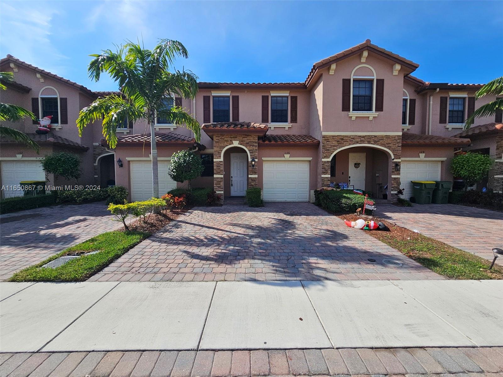 a front view of a house with a yard and a garage