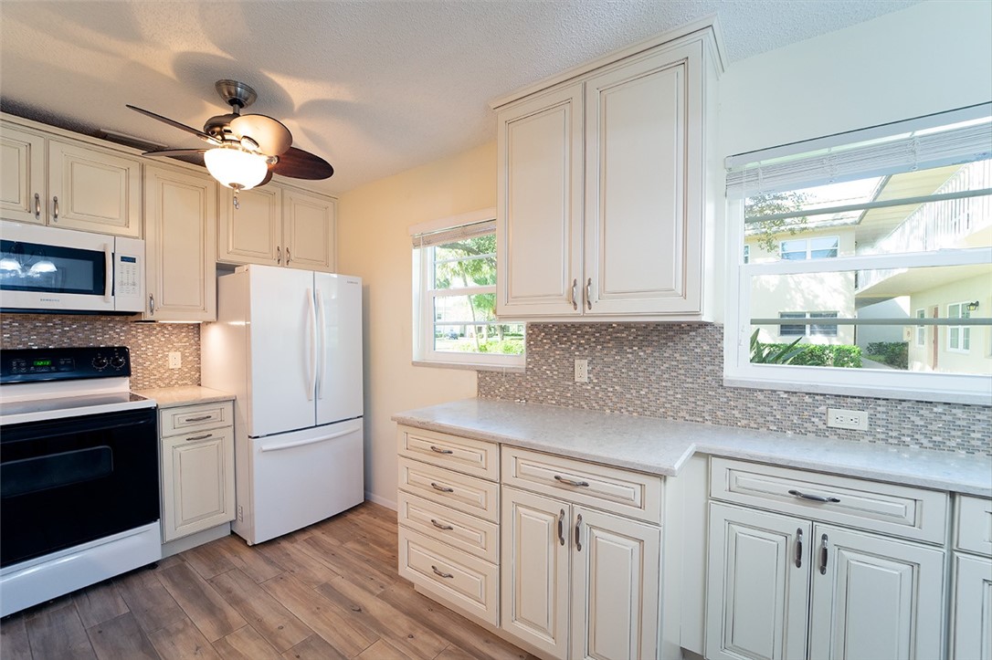 a kitchen with appliances cabinets a island and a window