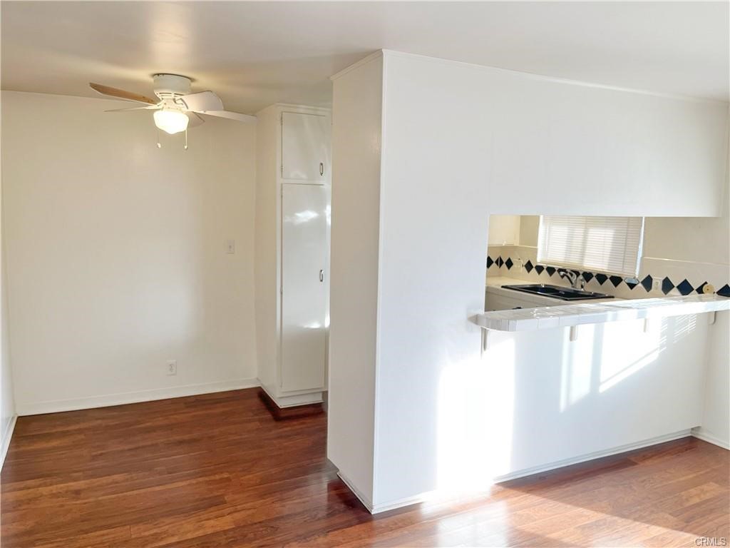 a view of a kitchen with an empty space and wooden floor