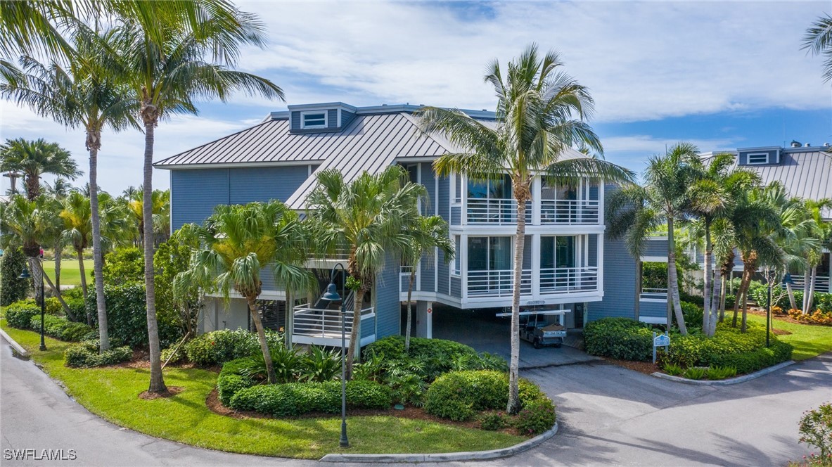 a view of a house with a small yard and palm trees