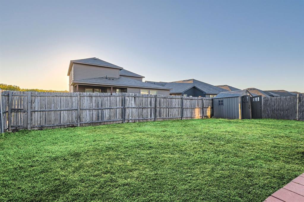 a view of a backyard with wooden fence