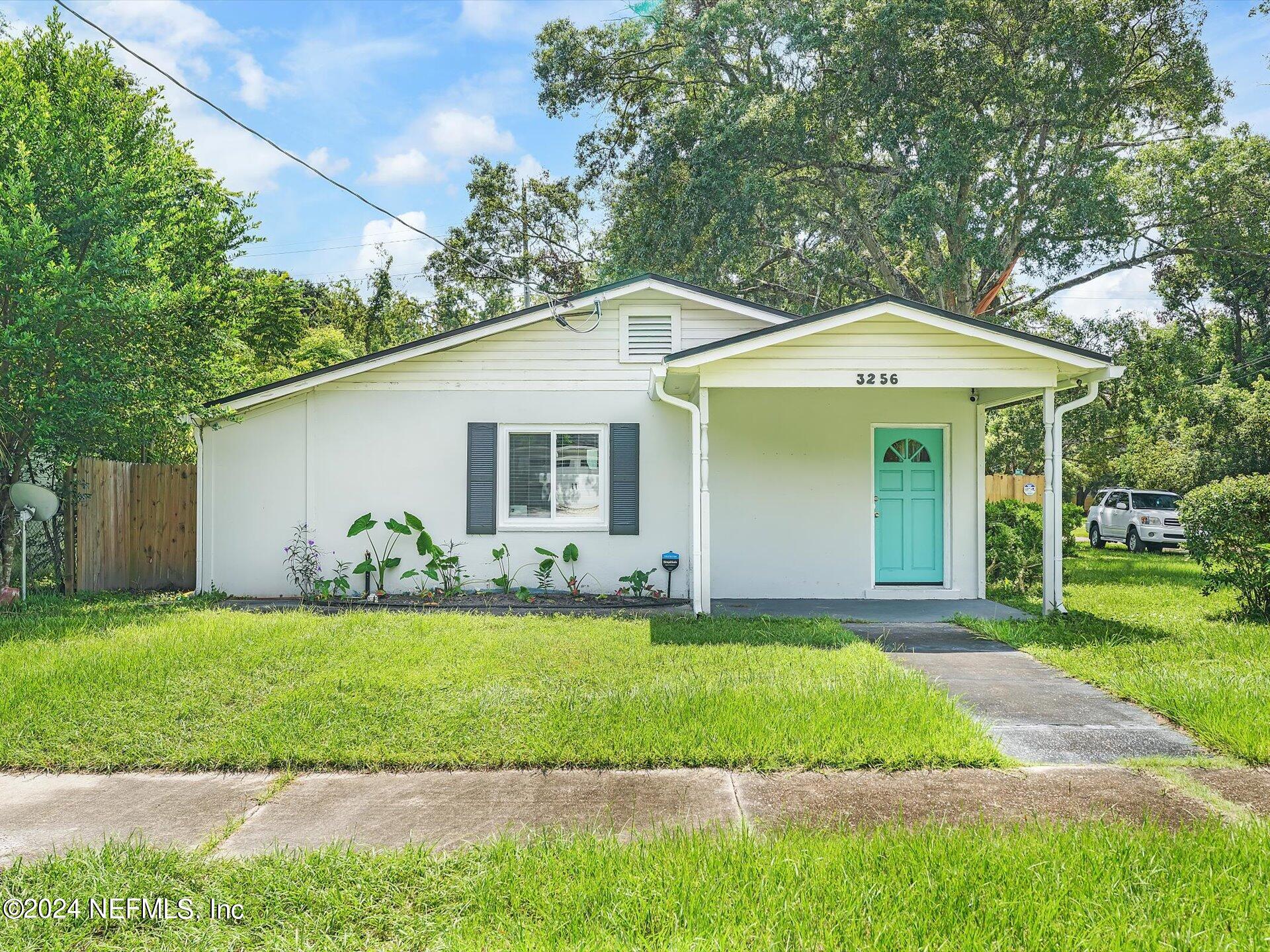 a front view of a house with a yard and trees