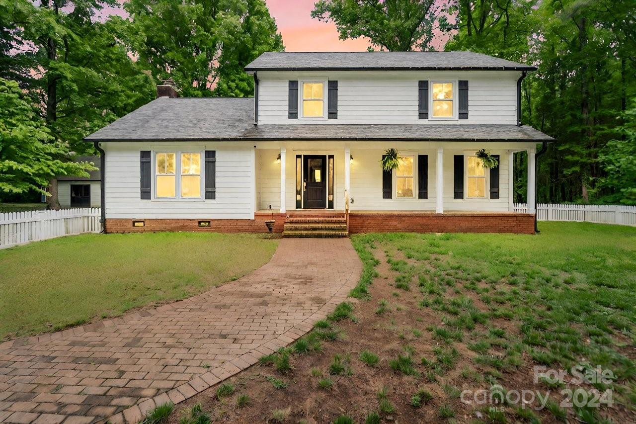 a front view of a house with a yard and green space