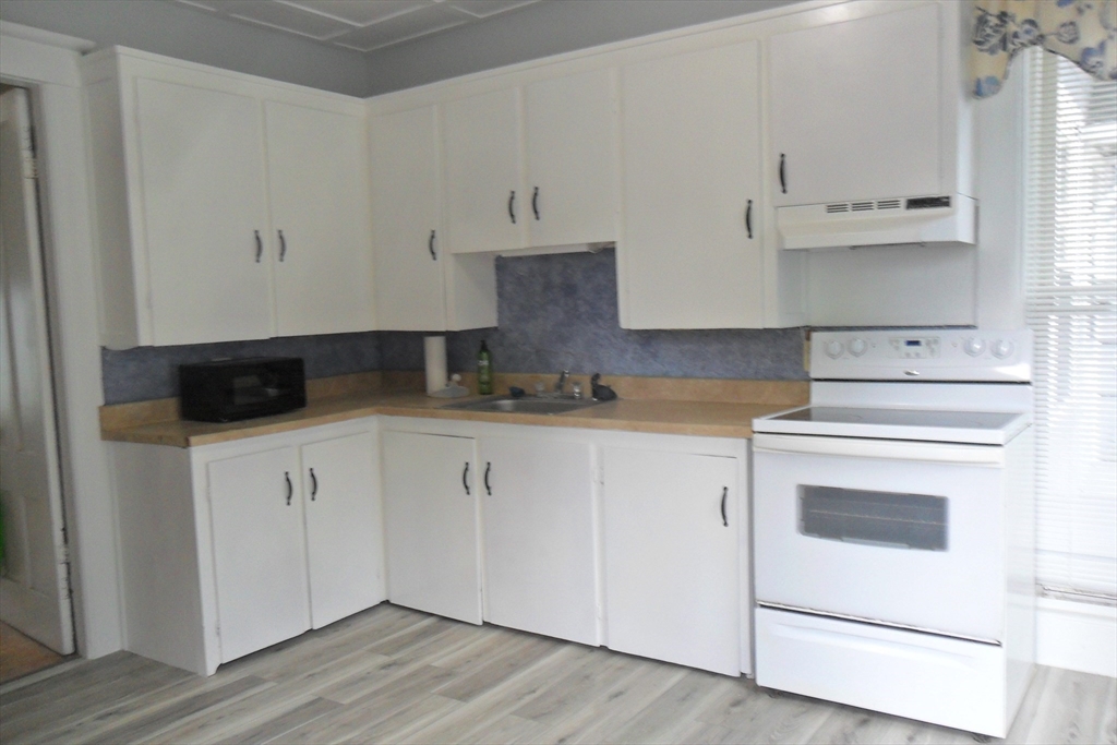 a kitchen with stainless steel appliances white cabinets and a sink