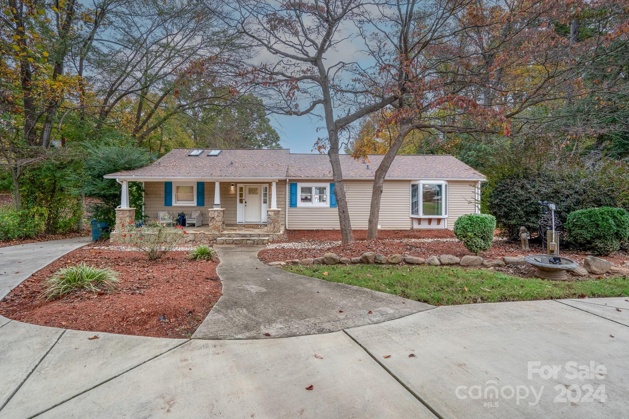 a front view of a house with yard and tree s