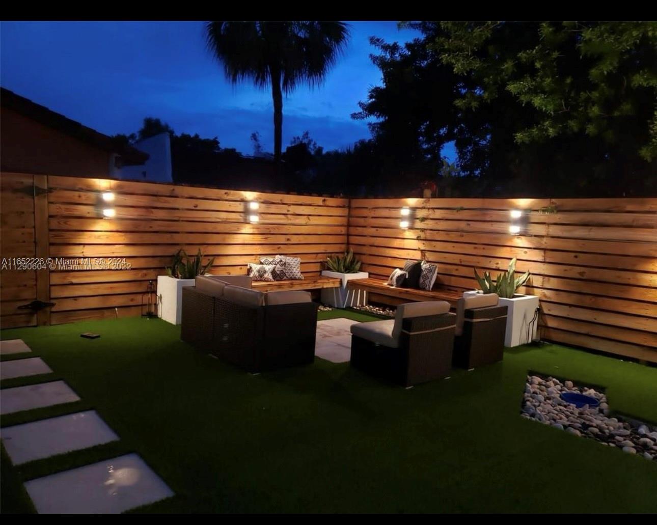 a view of a patio with table and chairs potted plants and a palm tree