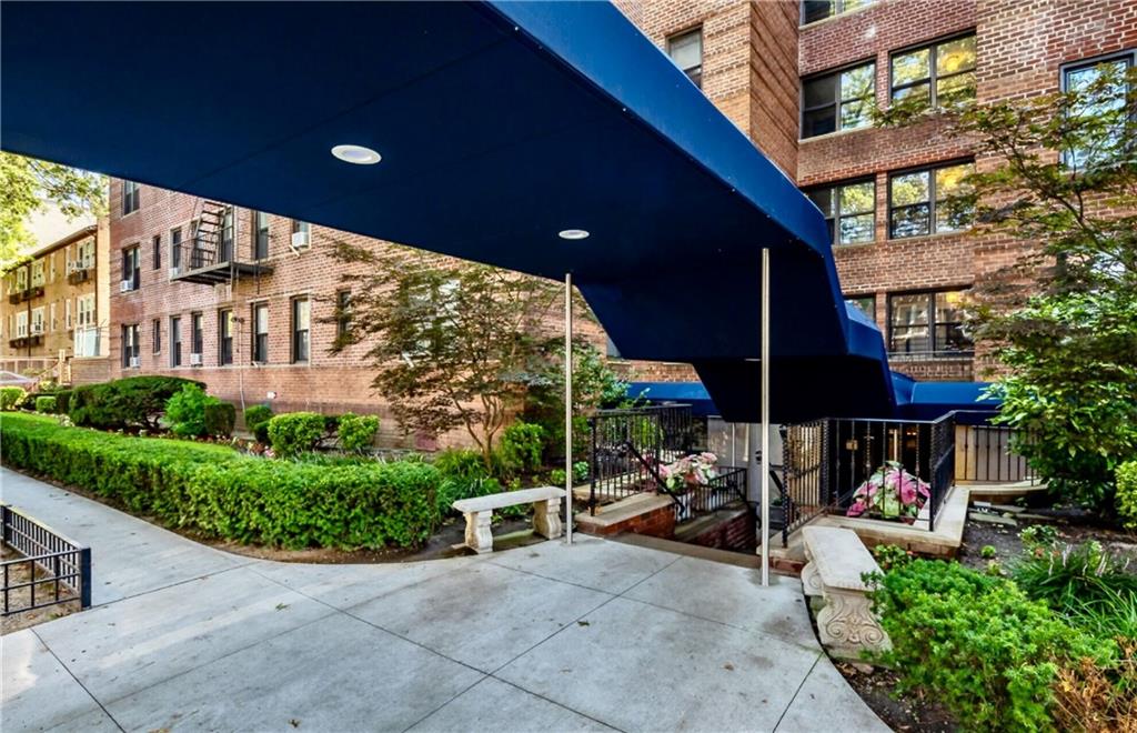 a view of a patio with table and chairs under an umbrella with a small yard