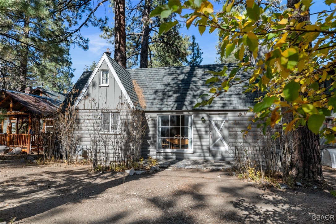 a view of a large house with large tree and wooden fence