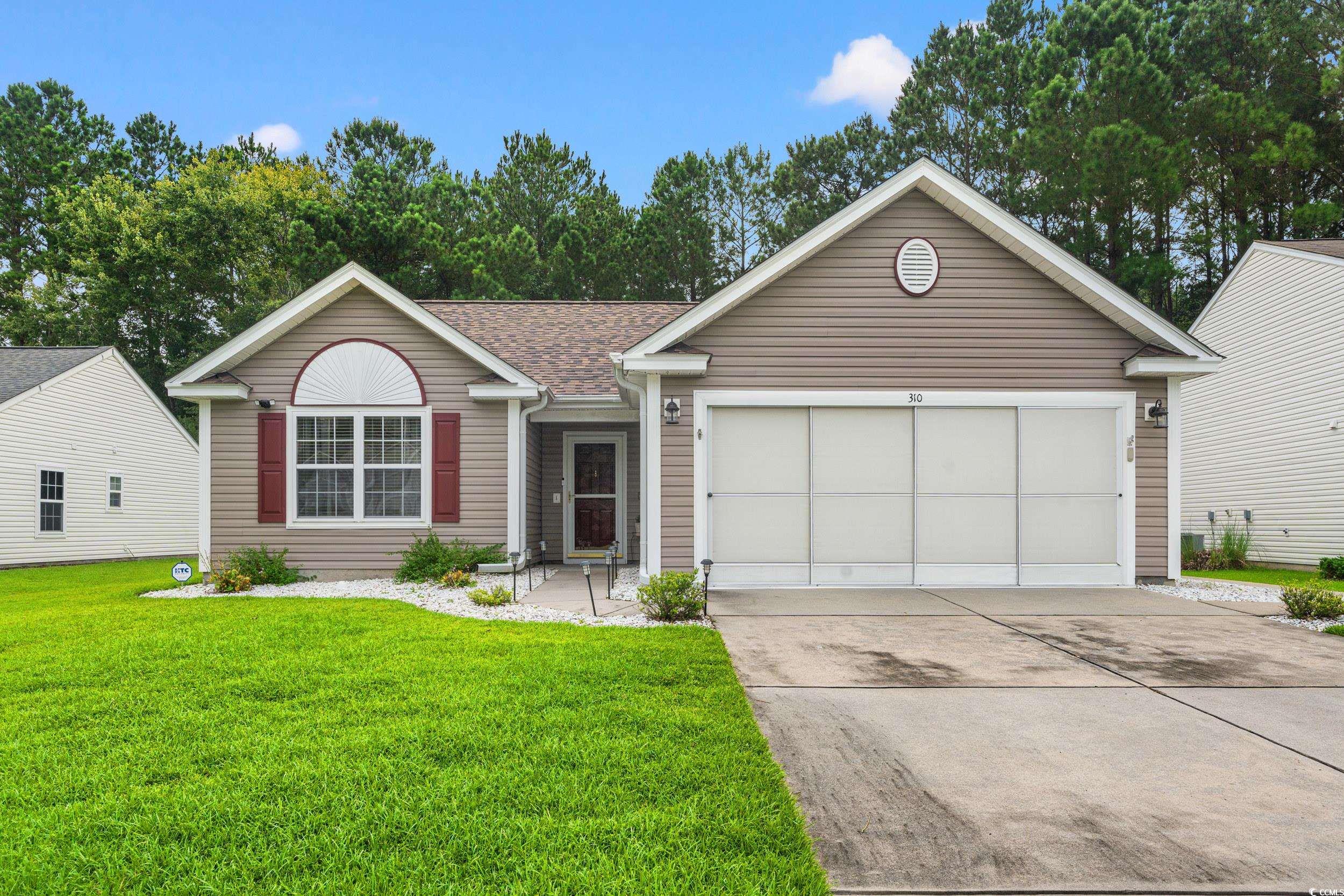 Ranch-style house featuring a front yard and a gar