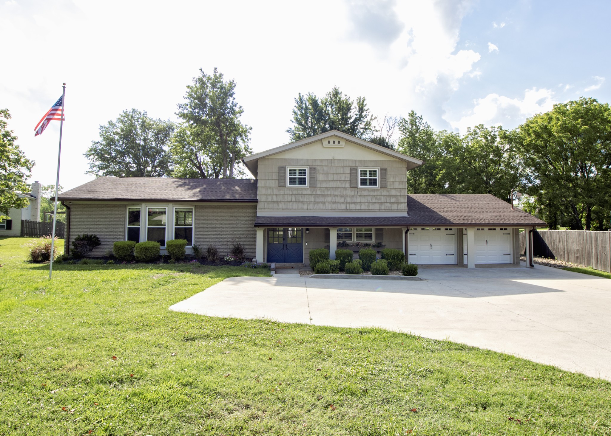 a front view of a house with a yard and trees