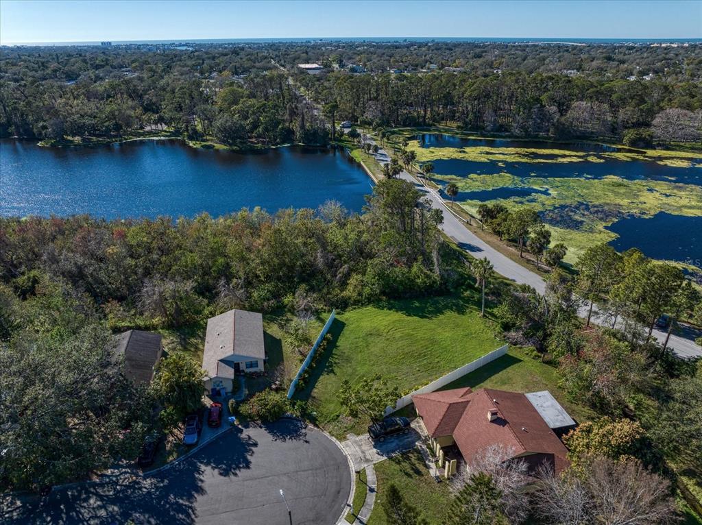 an aerial view of a house with a garden and lake view