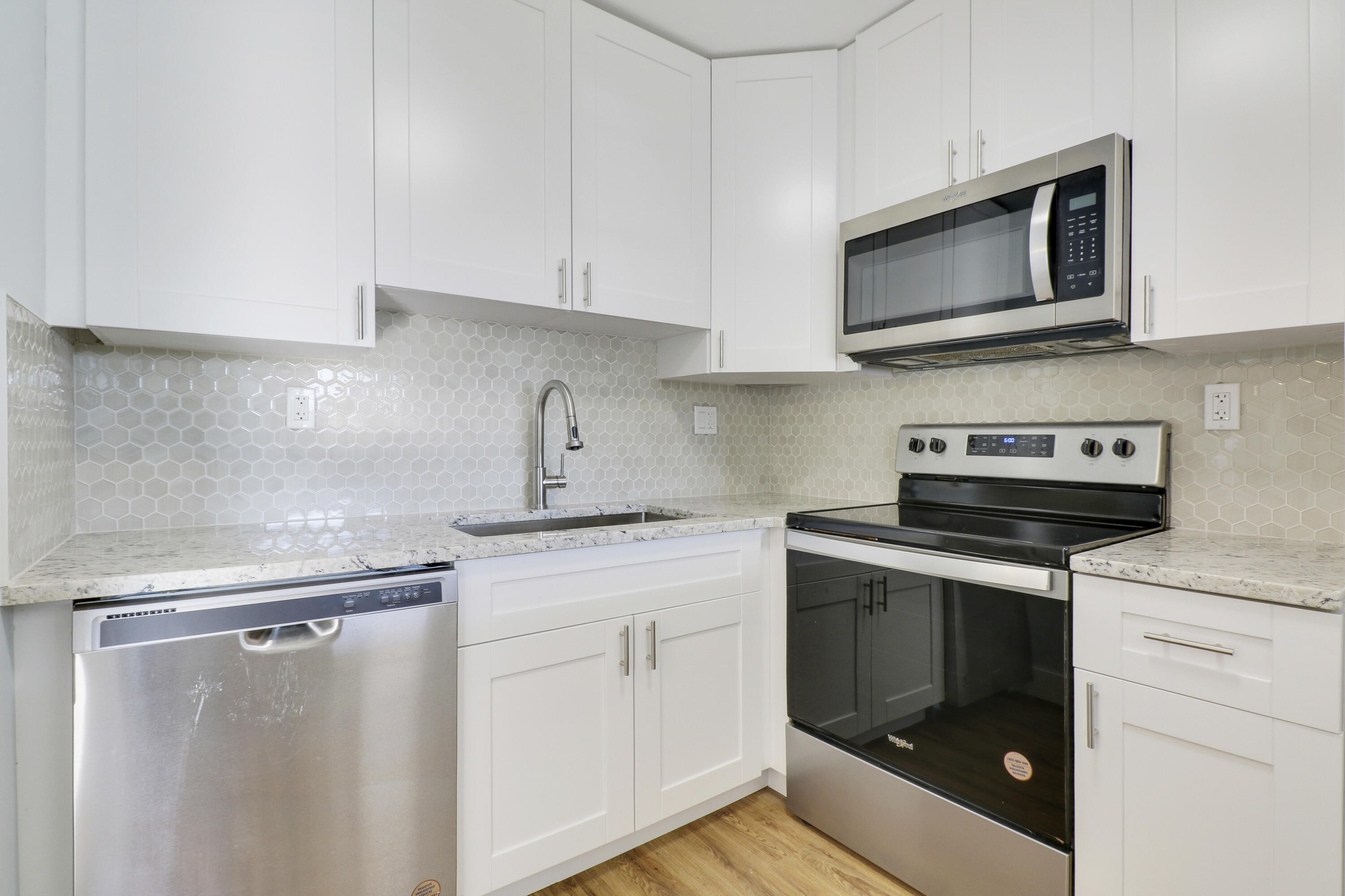 a kitchen with white cabinets stainless steel appliances and sink