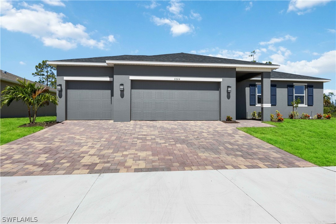 a front view of a house with a yard and a garage