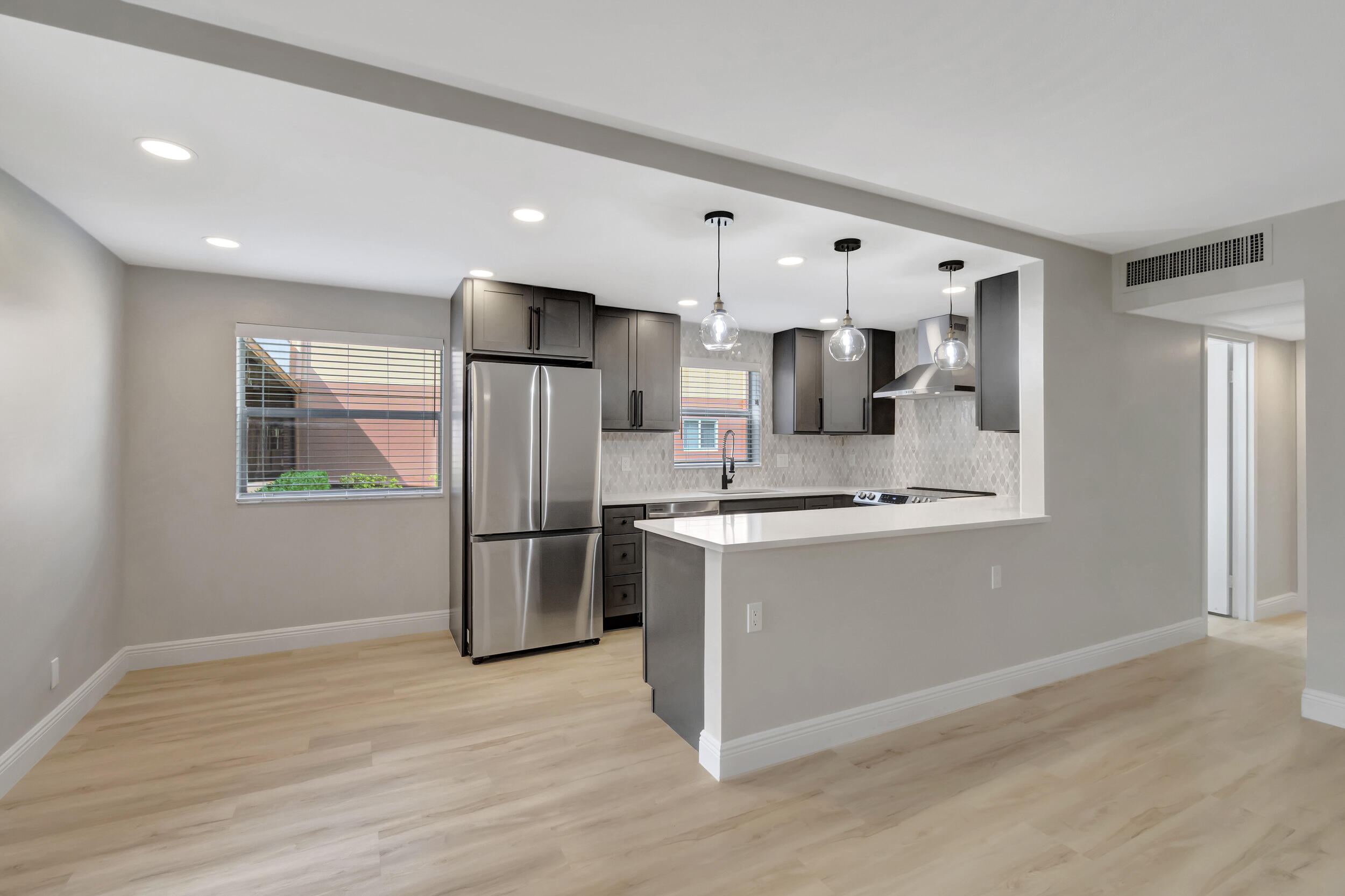 a large kitchen with stainless steel appliances a refrigerator and a stove top oven