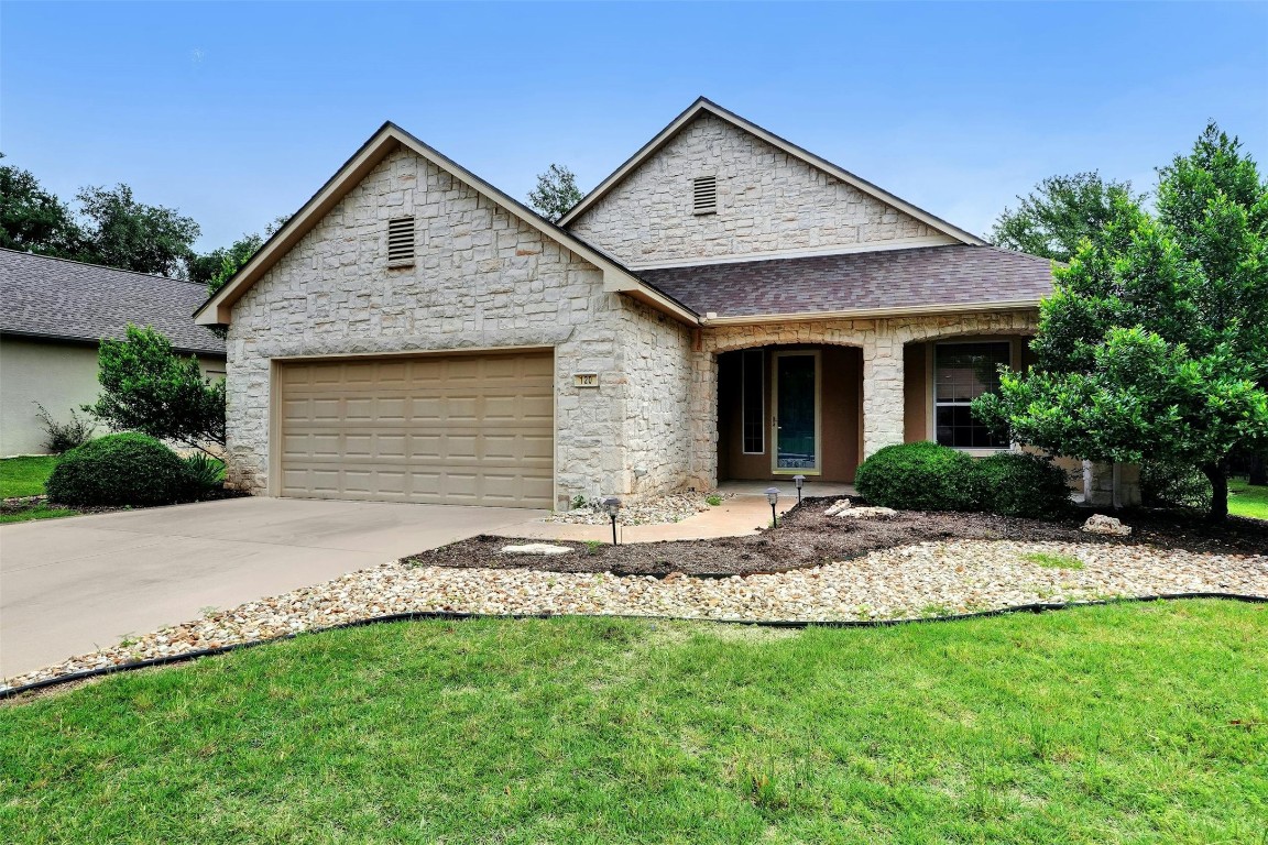 a front view of a house with a garden and yard