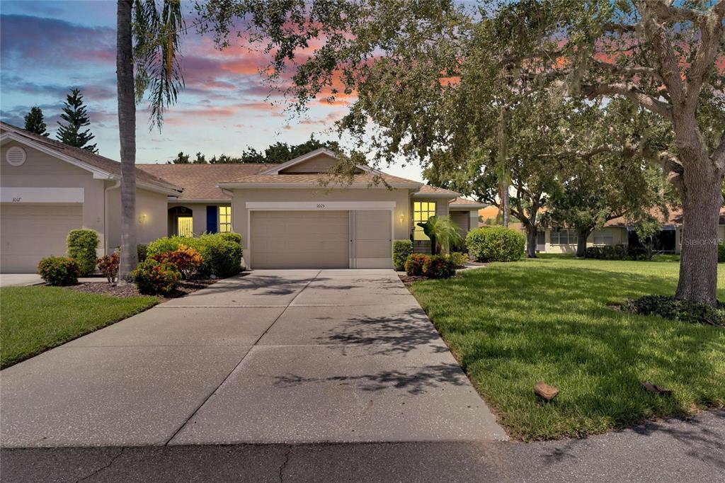 a front view of a house with a yard and trees