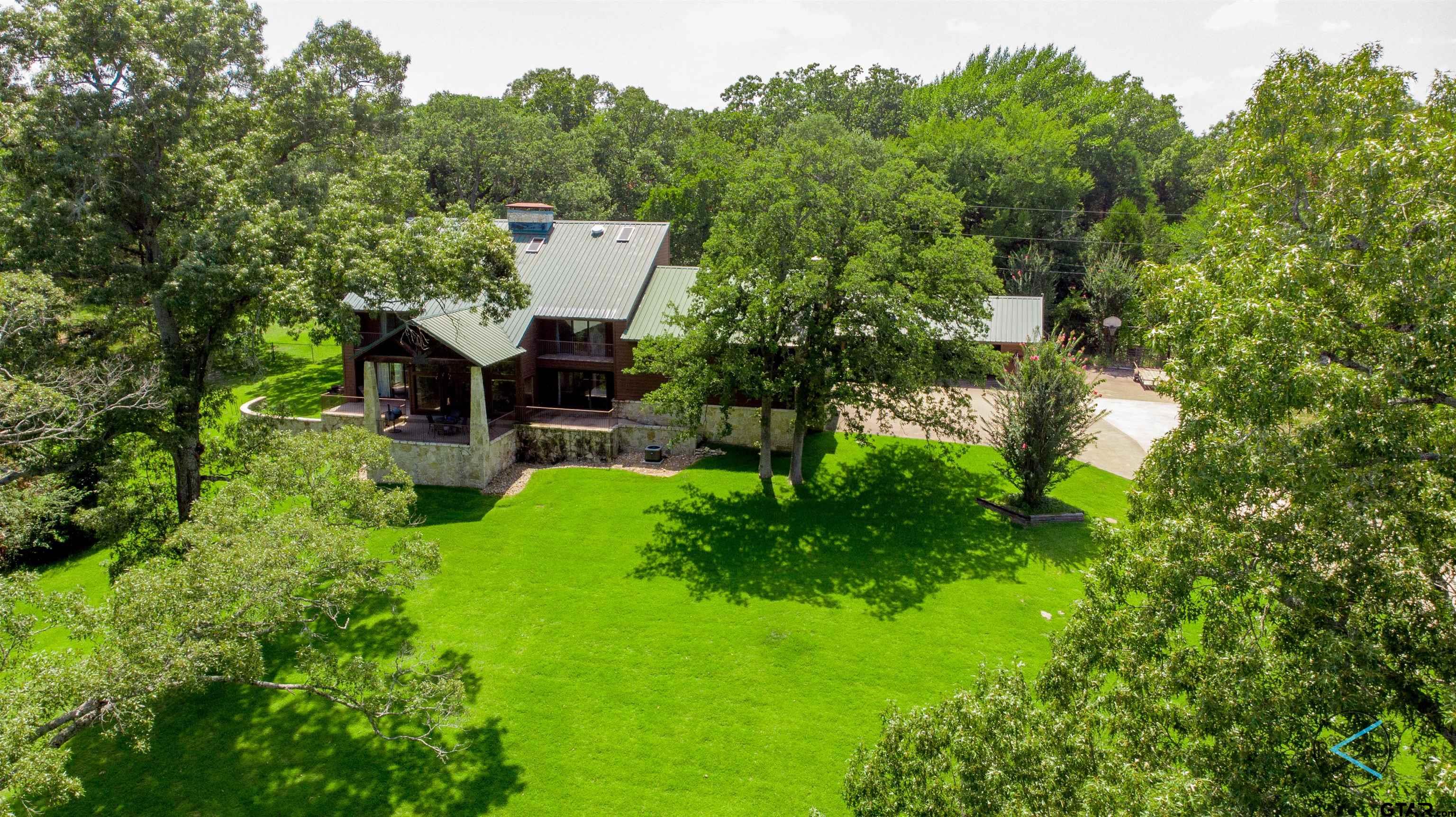 a view of a house with a backyard and trees