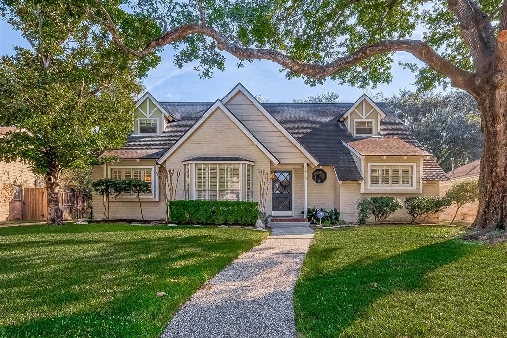 a front view of a house with a yard and trees