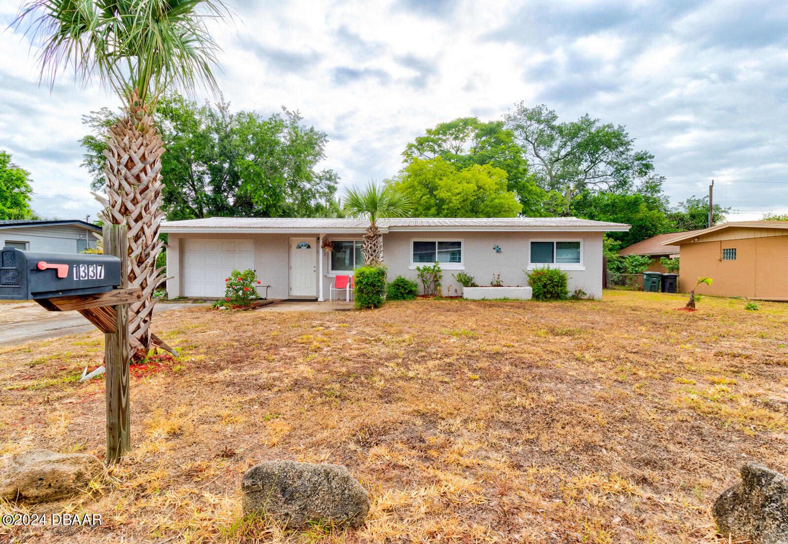 a front view of house with yard and trees around