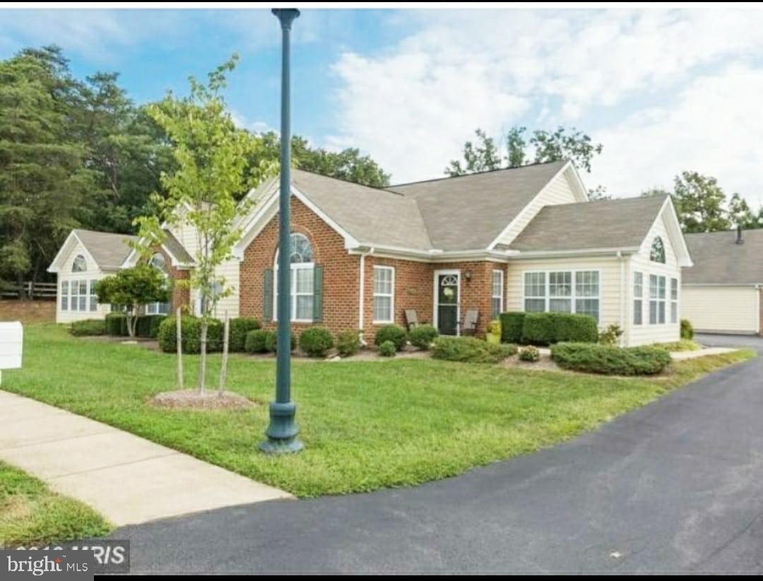 a view of a house with a big yard plants and large trees