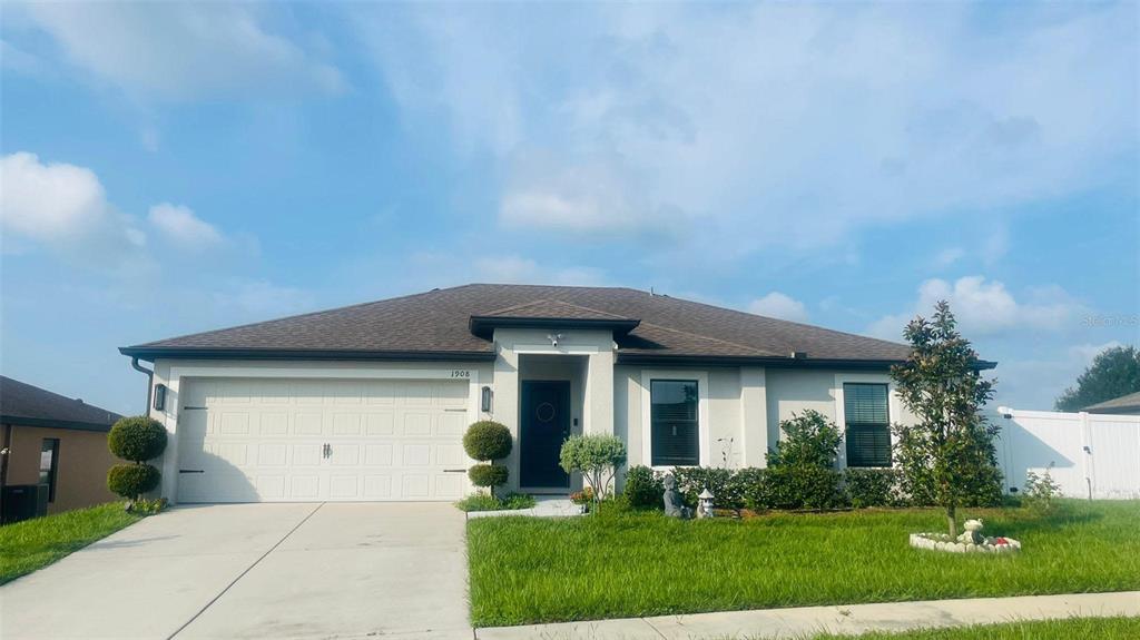 a front view of a house with a yard and garage