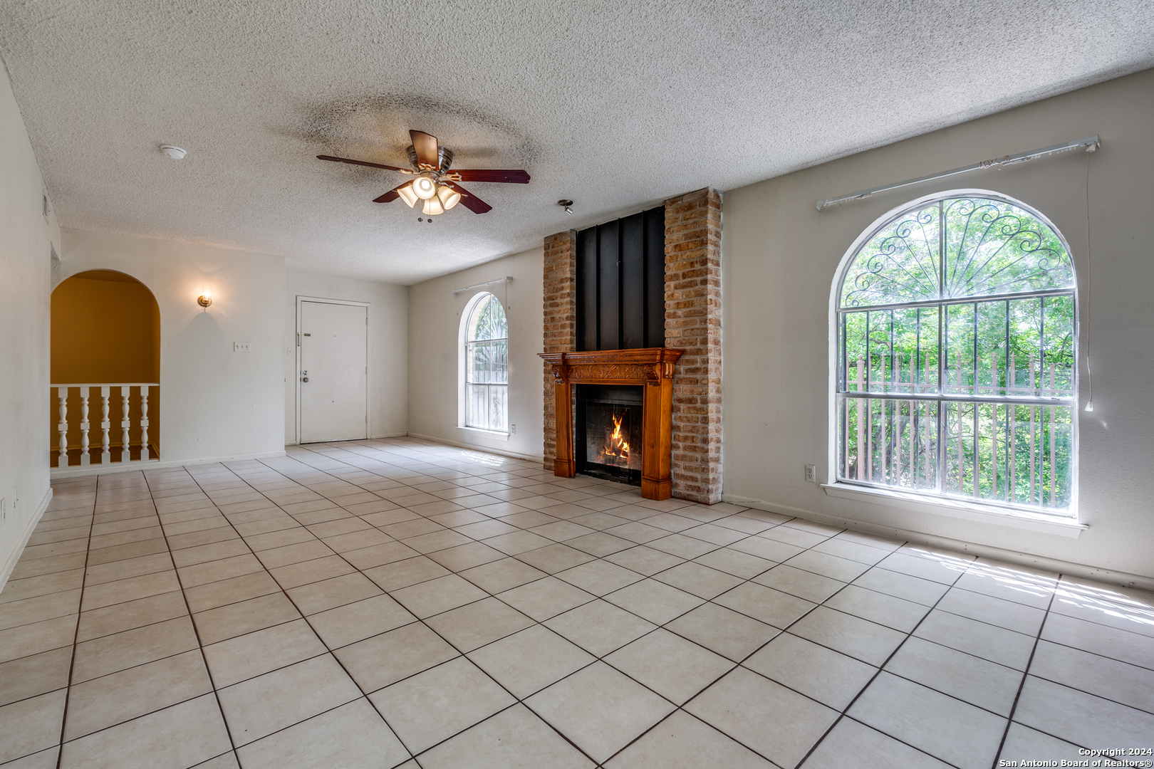 a view of an empty room with a fireplace and a window