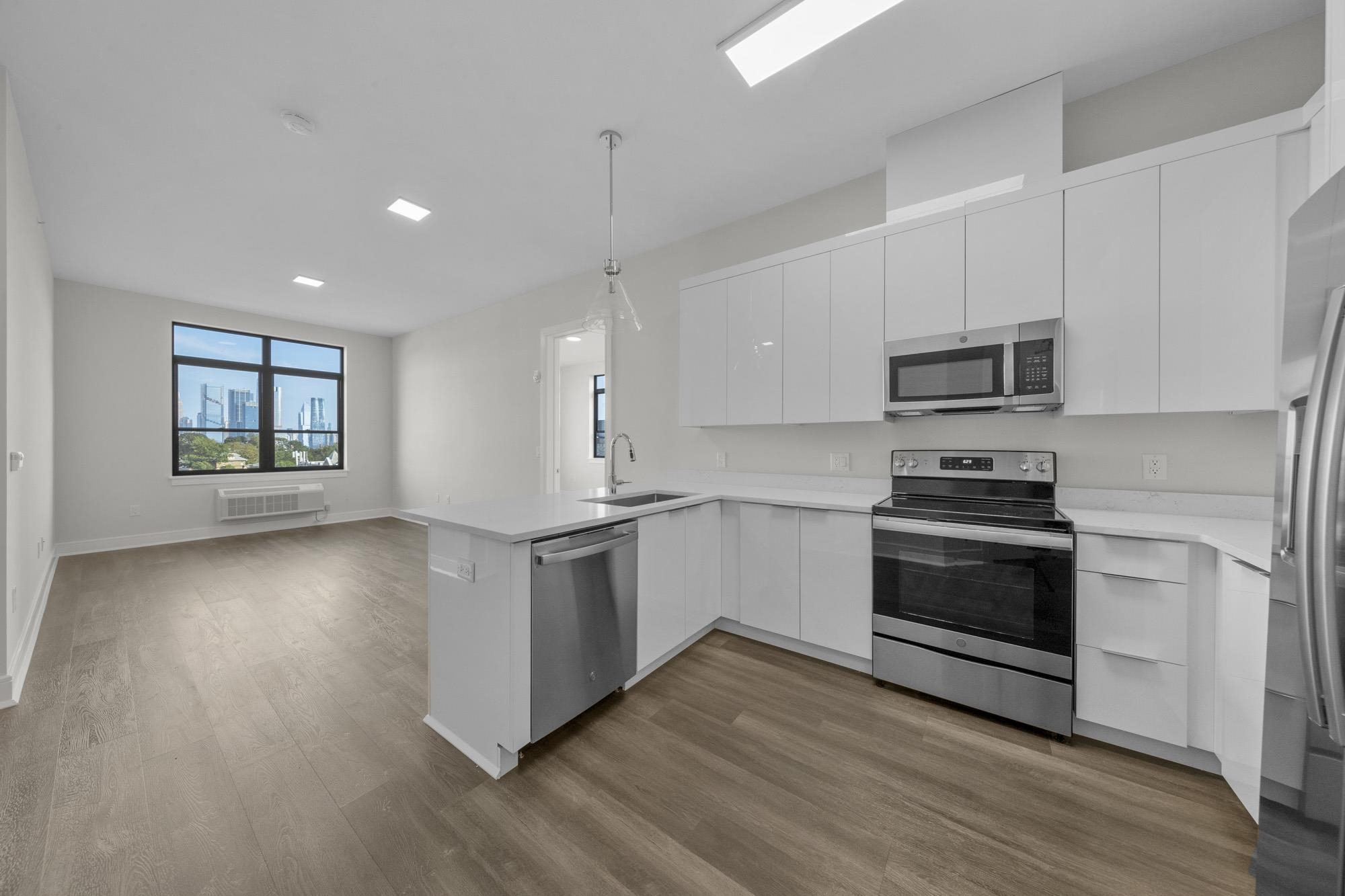 a kitchen with granite countertop a stove a sink and a microwave