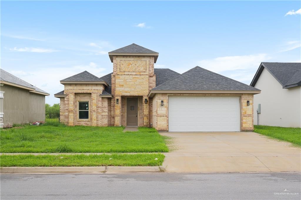 a front view of a house with a yard and garage