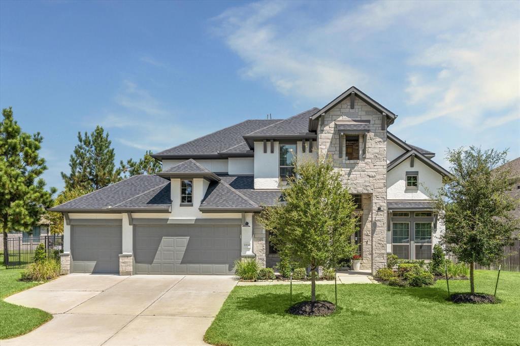 a front view of a house with a yard and trees