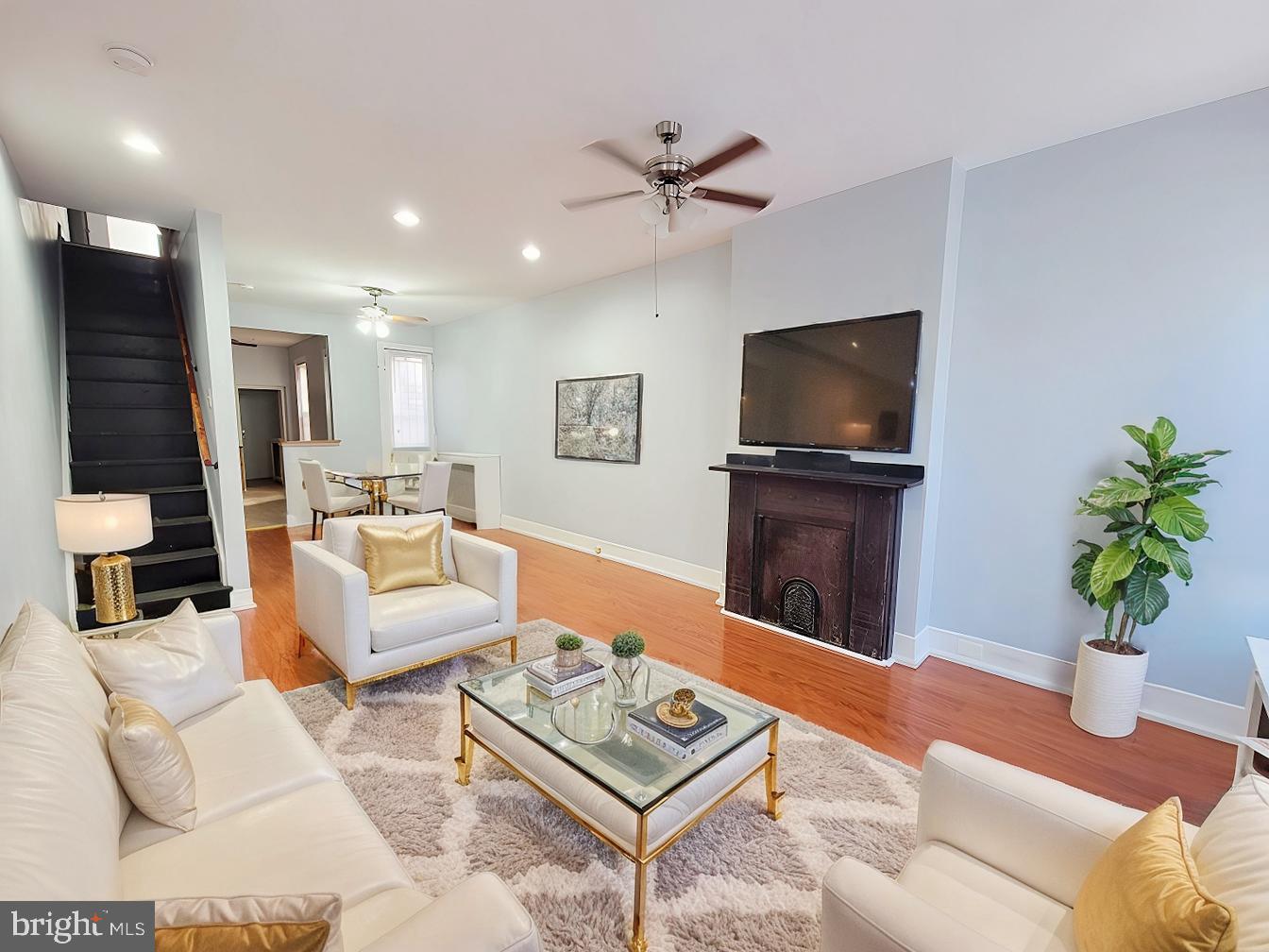 a living room with furniture a flat screen tv and a potted plant